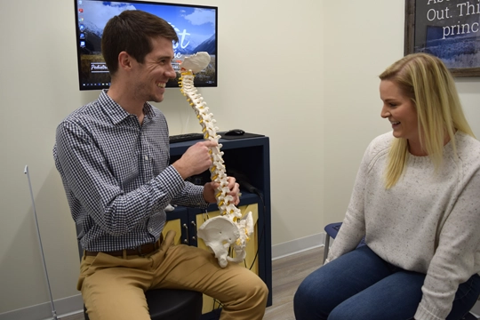 Chiropractor Wauwatosa WI Alexander Young Pointing To Spine Model